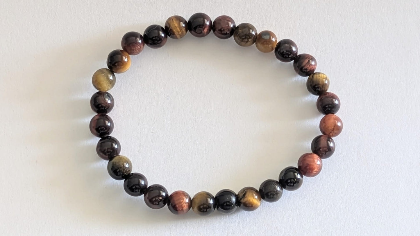 BRACELET EN ŒIL MIXTE (TIGRE • FAUCON • TAUREAU) – Perles 6 mm – Artisanat de Madagascar Pierre d’harmonie, protection & énergie équilibrée | Reflets dorés, bleutés et rouges | Bracelet élastique fait main